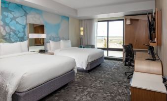 a hotel room with two beds , a desk , and a window overlooking a body of water at Courtyard Pasco Tri-Cities Airport