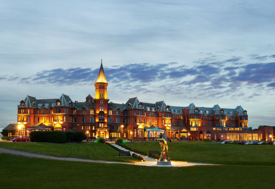 a large hotel complex with a statue in the foreground and a walkway leading to it at Slieve Donard