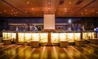 a modern , well - lit restaurant with a long marble counter and several chairs arranged around it at SHIROYAMA HOTEL kagoshima