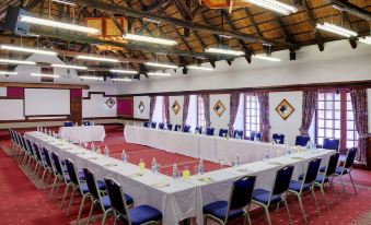 a large conference room with multiple tables and chairs arranged in a semicircle , creating an interesting setting for a meeting or presentation at Mokuti Etosha