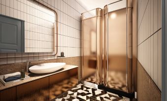 The bathroom features large tiles on the floor and walls, and it is enclosed at Sleeping Lion Suites