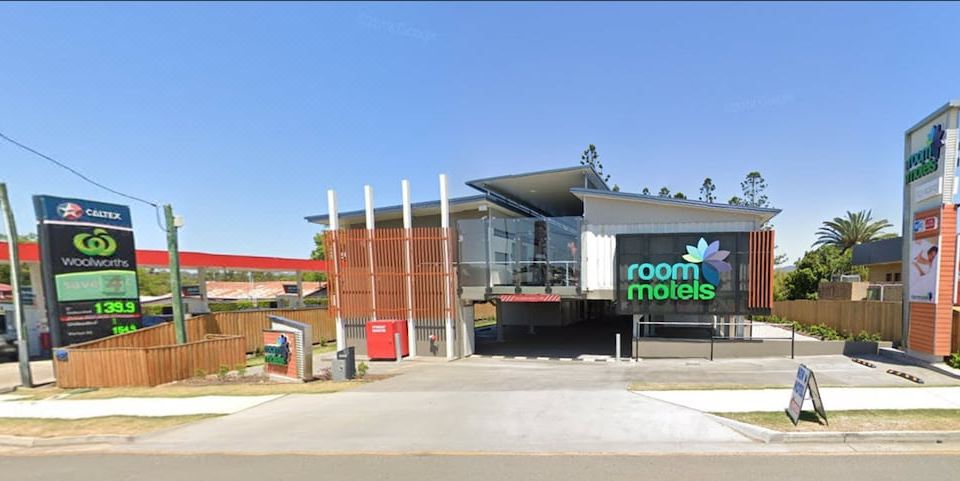 "a large building with a sign that says "" room miels "" is shown from the outside" at Room Motels Gympie