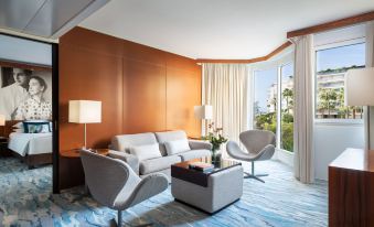 a living room with a couch , chairs , and coffee table in front of a window at JW Marriott Cannes