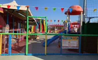 a colorful playground with various play structures , such as slides , swings , and a jungle gym at Hotel Cenacolo