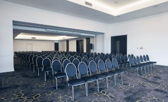 a large conference room with rows of chairs arranged in a semicircle , providing seating for a large group of people at Daydream Island Resort