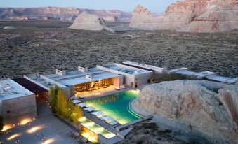 a modern , multi - level building with a pool and surrounding cliffs , set against a barren desert landscape at Amangiri