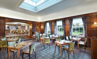 a dining room with wooden tables and chairs arranged for a group of people to enjoy a meal at Avisford Park Hotel