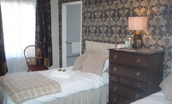 a bedroom with two beds , one on the left and one on the right side of the room at George Inn