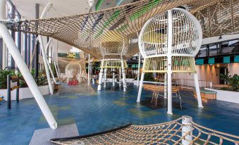 a large indoor play area with a hammock , monkey bars , and other play structures for children to enjoy at Mercure Sydney Liverpool