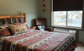 a cozy bedroom with a wooden bed , a window , and a tv on the wall at Rays Place Inn