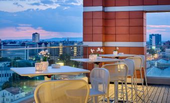a rooftop patio with several chairs and tables , providing a pleasant setting for people to relax and enjoy the view at NH Padova