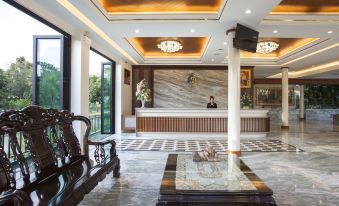a modern hotel lobby with marble floors , wooden paneling , and large windows , as well as a reception desk and seating area at Parn Dhevi Riverside Resort & Spa