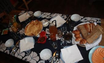 a dining table set with a variety of food items , including pies , pastries , and coffee at La Vieille Ferme