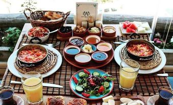 a dining table set with a variety of food items , including sandwiches , salads , and other dishes at Azure Cave Suites - Cappadocia