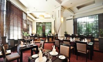 a large , elegant dining room with multiple tables and chairs arranged for a group of people at Tara Angkor Hotel