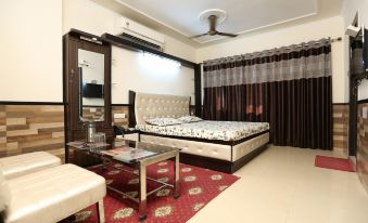 bedroom with a spacious bed and a table positioned in the center, accompanied by an elegant ambiance at Bombay Picnic Spot Hotel & Resort