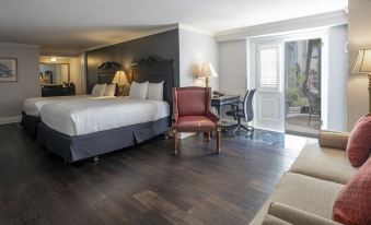 a spacious bedroom with hardwood floors , a king - sized bed , and a chair in the corner at Bourbon Orleans Hotel