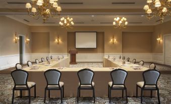 a large conference room with multiple chairs arranged in rows , and a projector screen on the wall at Rosewood Bermuda
