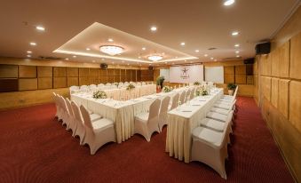 a large conference room with tables and chairs arranged for a meeting or event , possibly a wedding reception at Super Hotel Candle