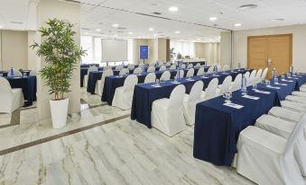 a large conference room with multiple rows of chairs arranged in a semicircle , creating an elegant setting for a meeting at Hesperia Vigo