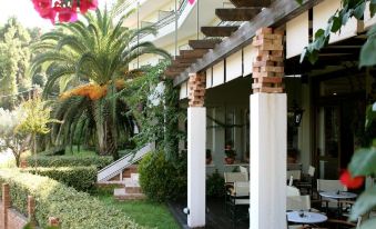 a brick building with a balcony overlooking a tropical garden , creating a serene and inviting atmosphere at Hotel Antonios