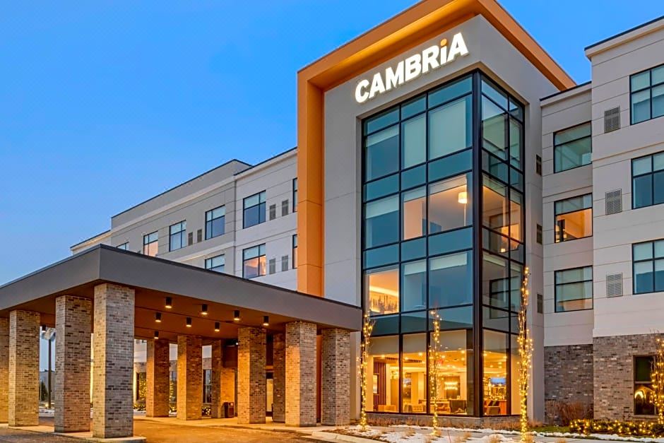 "a large hotel with a modern design and the name "" cambria "" displayed above the entrance" at Cambria Hotel Detroit-Shelby Township