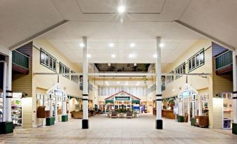 an indoor shopping mall with a large open space and multiple stores , including a clothing store at Cairns Colonial Club Resort