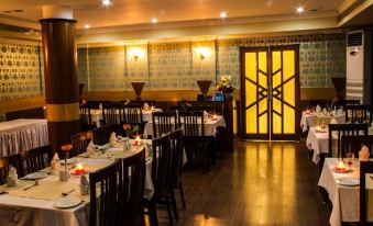 a well - decorated restaurant with multiple dining tables and chairs arranged for guests to enjoy a meal at The Presidency