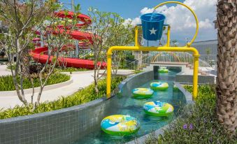 a water park with multiple water slides , including one with a blue bucket on top at Alma Resort Cam Ranh