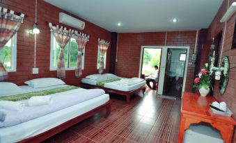 a hotel room with three beds , one on the left , one in the middle , and one on the right at I Din Lake View Resort Nakhon Nayok