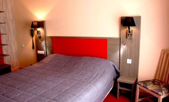 a bed with a red headboard and gray bedding is situated between two lamps on either side of a wall at Hotel Saint-Hubert