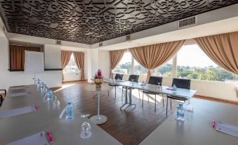 a conference room with a large table , chairs , and water bottles is set up for a meeting at Allegro Agadir