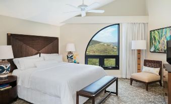 a bedroom with a large bed , white linens , and a view of the mountains through a window at The Westin St. John Resort Villas