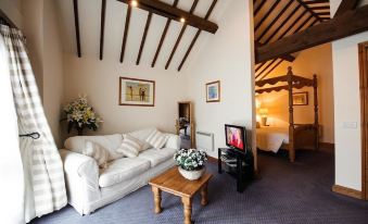 a cozy living room with a white couch , wooden coffee table , and flat - screen tv at Church Farm Lodge