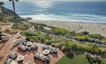 a beautiful beach scene with a group of people enjoying the view from an upper level at The Ritz-Carlton, Laguna Niguel