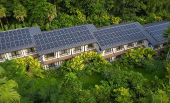 aerial view of a residential building surrounded by lush greenery , with solar panels on the roof at Tabacon Thermal Resort & Spa