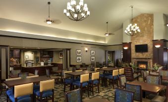 a dining room with a long table and chairs , a fireplace , and a chandelier hanging from the ceiling at Homewood Suites by Hilton Dover - Rockaway