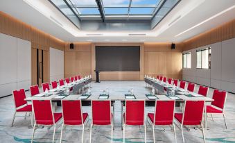 The hotel offers a spacious conference room equipped with red chairs and long tables, suitable for meetings and other business events at Holiday Inn Shanghai Nanjing Road