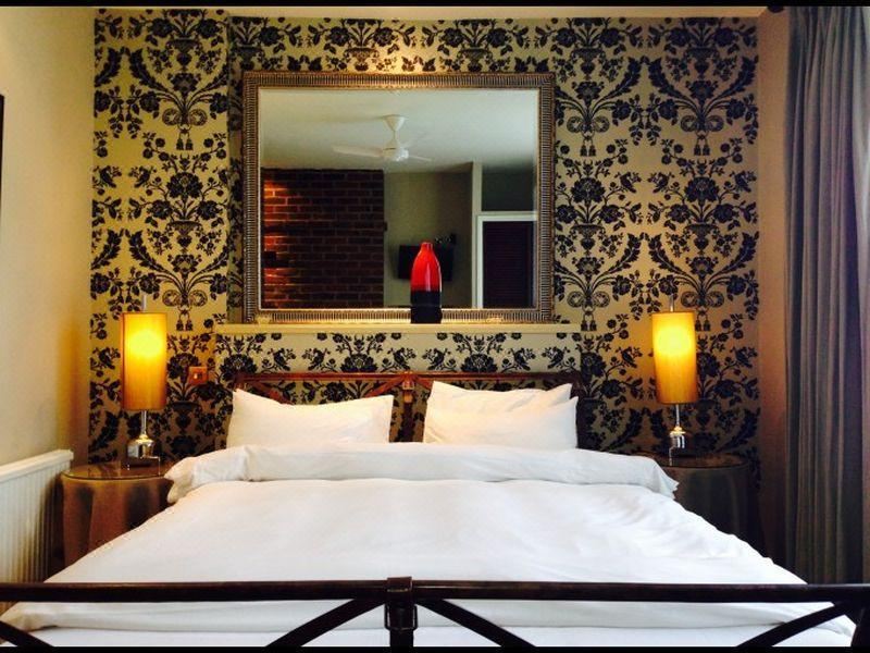 a cozy bedroom with a large bed and two lamps , creating a warm and inviting atmosphere at Manor Hotel