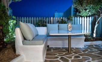 a white couch and table are placed in a backyard with a fence surrounding it at Hotel Iris