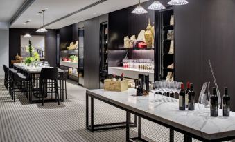 a well - organized wine shop with various bottles and glasses on display , along with a black wall and white ceiling at InterContinental Sydney Double Bay, an IHG Hotel