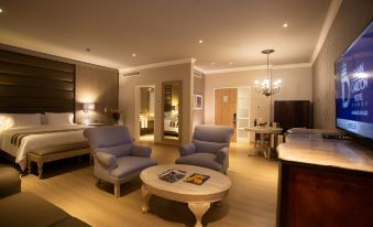 a modern living room with blue furniture , a white coffee table , and a chandelier , set in an elegant interior design at Dann Carlton Medellin Hotel