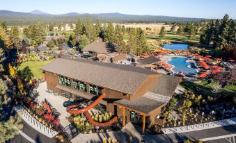 aerial view of a resort with a large pool surrounded by lounge chairs , tables , and chairs at Sunriver Resort