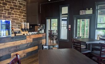 a dining room with wooden tables and chairs , along with a bar area with stools at Inn at the Falls