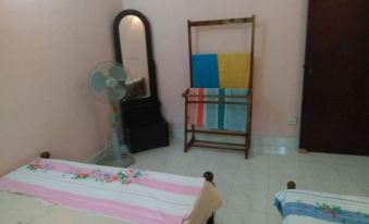 a bedroom with a bed , fan , and a mirror , along with some colorful towels on the floor at Rivers Edge