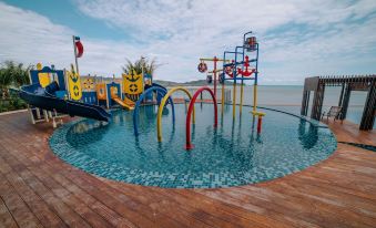 a colorful water park with various water slides and play structures , situated near a body of water at Swiss-Belhotel Kuantan