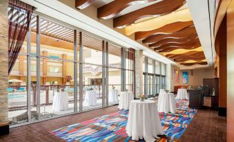a large , modern hotel lobby with white tables and chairs set up for an event at Gila River Resorts & Casinos – Vee Quiva