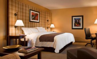 a hotel room with a king - sized bed , two nightstands , and a couch in the corner at DoubleTree by Hilton Hotel Cincinnati Airport