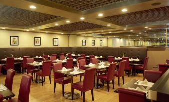 The restaurant features red leather chairs, a wood-paneled ceiling, and accompanying side tables at Best Western Plus Hotel Hong Kong