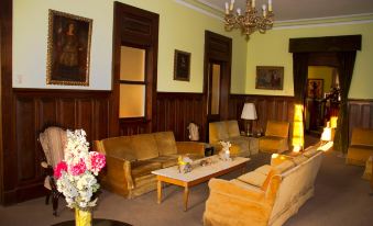 a well - decorated living room with wooden paneling , multiple couches , and a chandelier hanging from the ceiling at Las Mercedes